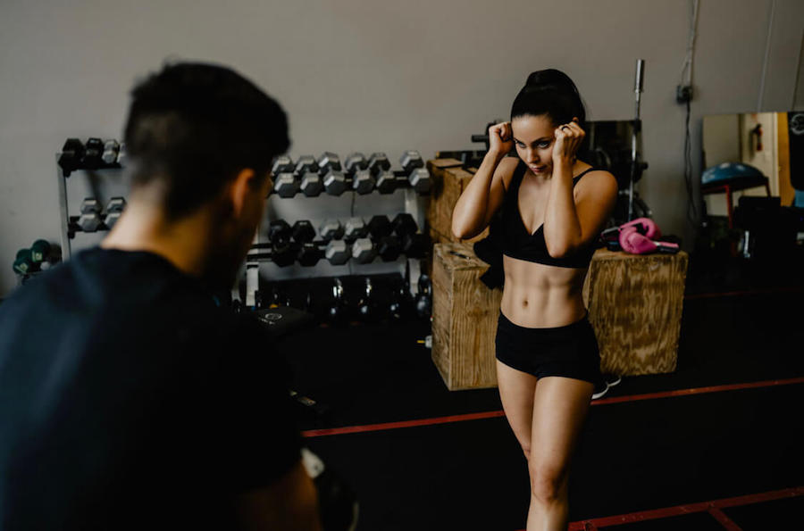 Woman boxing and working out with a trainer at her personal gym