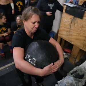 Woman doing ab workouts with a medicine ball and weights